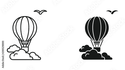 Black and white hot air balloons flying in the sky with clouds and birds