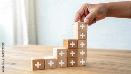hand building a tower with wooden blocks with white crosses on a table