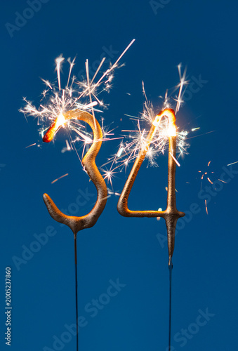 34 years celebration festive background made with Bengal fires in the form of number Thirty four. Vertical photography.
