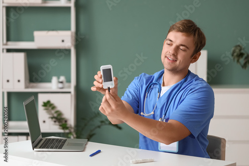 Male doctor with glucometer...