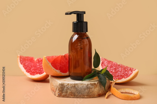 Cuadro en lienzo Bottle of cosmetic product, pieces of grapefruit and stone on beige background,