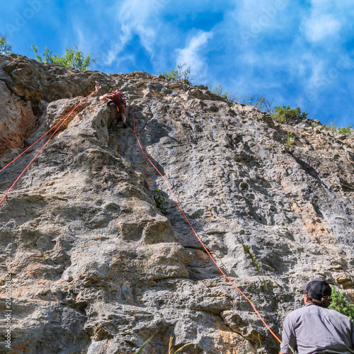 Lead Climber With Belayer On Steep Limestone Route