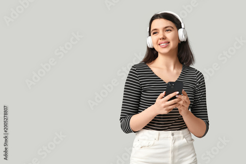 Happy young woman with mobi...