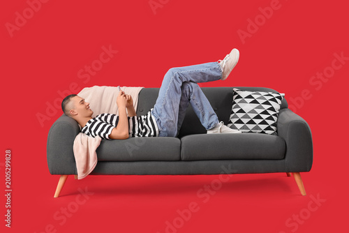 Happy young man lying on so...