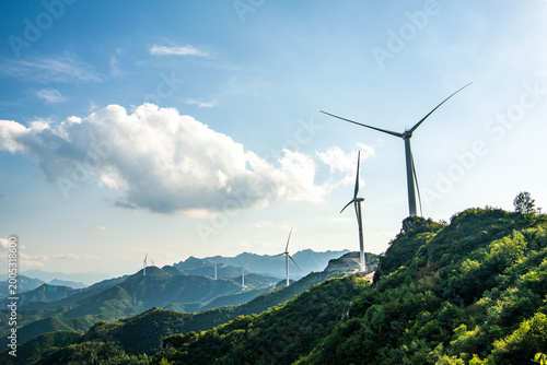 Fotografie Wind turbines on green mountain ridges in rural China, representing renewable energy development and sustainable power generation