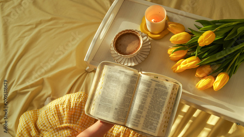 Fotografie Morning devotion with coffee, tulips, and a Bible on a yellow bedspread