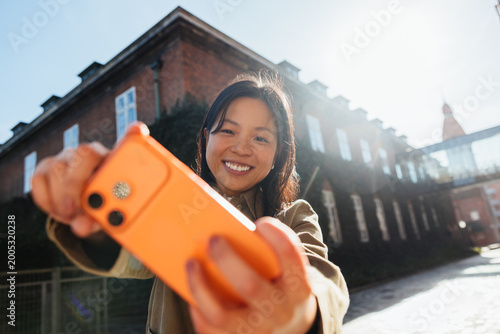 Young woman taking a smartphone selfie outdoors