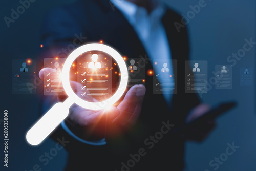 Fotografie An HR manager in a suit evaluates multiple digital candidate cards during the hiring process