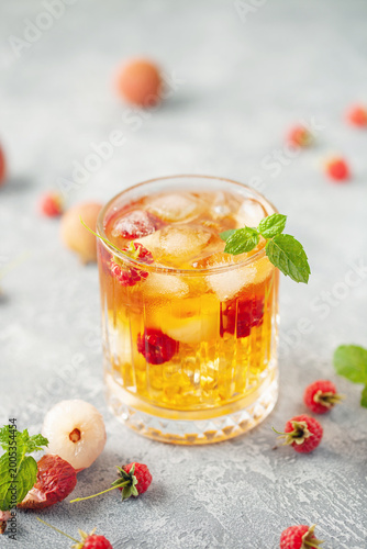 Lychee raspberry iced tea with mint leaves in glass. Summer drink