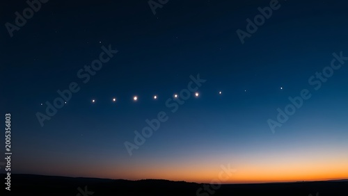 Six bright points of light aligned in the twilight sky above a dark, silhouetted horizon.