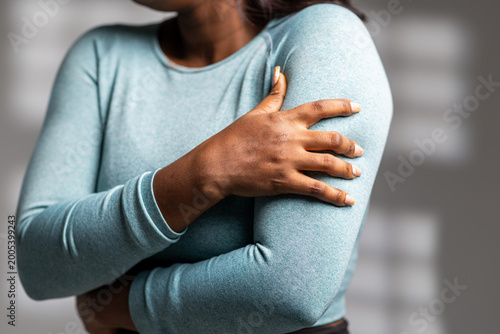 Photography African woman experiencing discomfort and pain in her shoulder and upper arm