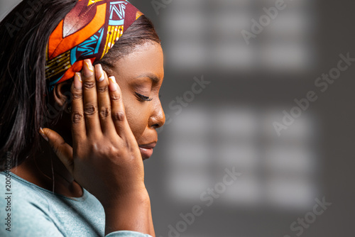 Foto African woman experiencing discomfort and pain, holding her head