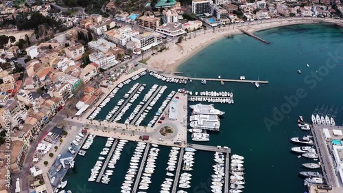 Port de Sóller, Mallorca, Spain - March 21, 2024: Breathtaking flying drone Aerial Perspective of Mediterranean Sea Harbor, Overflowing with Magnificent Luxury Yachts at Bustling Marina Docks and Port