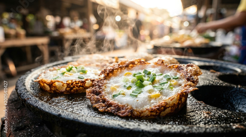 Crispy fried egg with green onion and corn cooking on hot pan with steam rising in street food market setting, showing texture and warmth