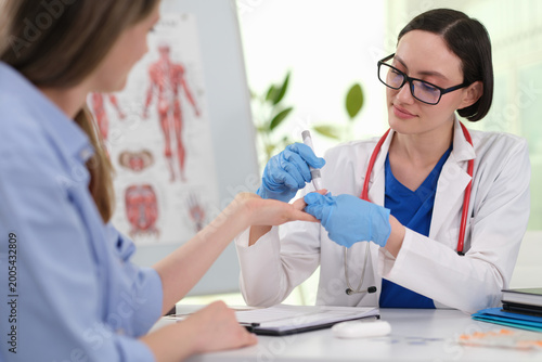 Canvas Print Clinician performing fingerstick blood glucose test, lancet and meter in use, im