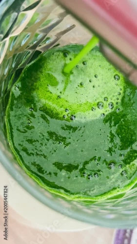 Green smoothie in glass with bright green color and healthy ingredients  