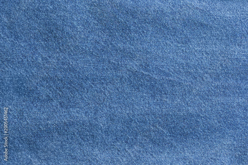 Indigo woven textile for designers. Neutral background showcasing indigo dyed denim material texture. Fabric swatch featuring dense woven blue denim pattern with classic indigo coloration