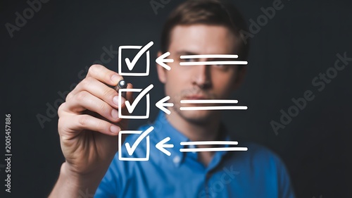 Man drawing a checklist with a pen on a transparent surface against a dark background