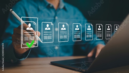 Person selecting a candidate with a digital pen evaluating potential job applicants resumes for recruitment