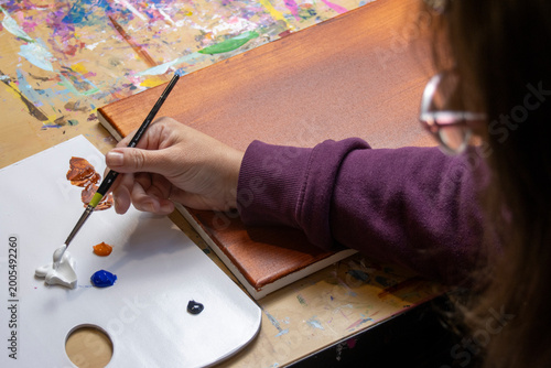 Fotografie Art workspace with artist, flat lay overhead view, picking up paint