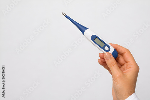 Human Hand Holding Thermometer ,Fever Check, Healthcare and Medical Concept,Fever Detection, Medical Diagnosis and Healthcare Concept,temperature Measurement, Health Monitoring and Clinical Concept