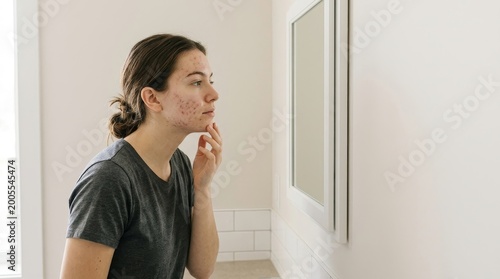 Self-care routine woman assessing skin condition in bathroom reflective environment personal care focus