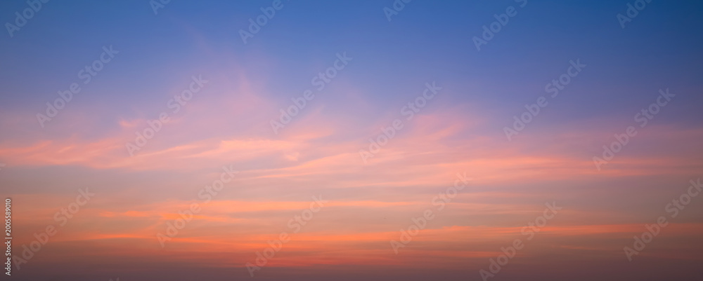 Fototapeta premium Evening Sky Panoramic Background with Orange and Pink Soft Clouds on Blue Nature Sunset Sky, Colorful Tropical Sunrise Natural Backdrop