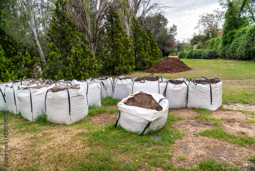 Photography White bulk bags filled with soil and compost on grass, preparing for landscaping