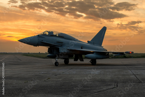 Fotografie Caza de combate en la pista de aterrizaje durante un amanecer dorado