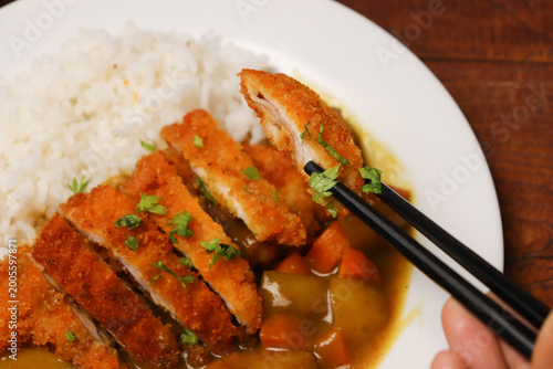 Crispy pork slices rest on rice and curry