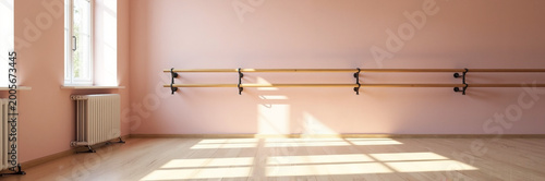 Dance studio interior with pink walls and wooden ballet barres illuminated by natural light. Dance studio features spacious layout with wooden flooring and large windows for bright atmosphere.