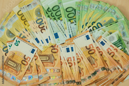 Принти на полотні Euro banknotes are arranged in grouped stacks by denomination on a wooden surface