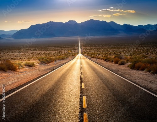 a long road in the desert heading towards the mountains an image that conveys themes of journey freedom and the future