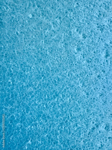 Close-up of a blue rough textured surface with fine grain and subtle variations, creating an abstract background suitable for design, overlays, and minimalistic visual compositions