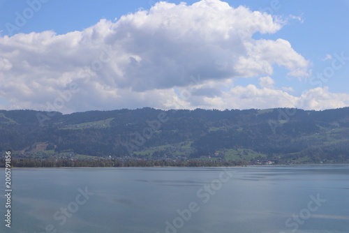 Obraz na plátně Wide serene panoramic view of a calm misty alpine lake with mirror-like water su