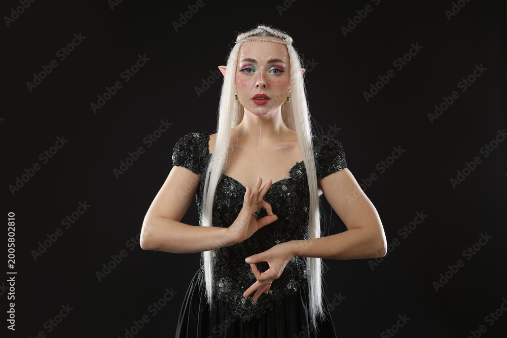 Naklejka premium Beautiful girl dressed as elf on black background