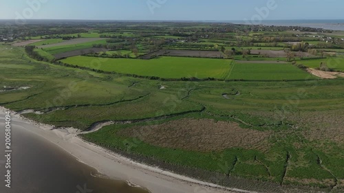 Survol de la Sienne, rivière entre Regnéville-sur-Mer et Heugueville-sur-Sienne, peu avant sa rencontre avec la Manche. Traveling latéral présentant l'amont et l'aval de la rivière.