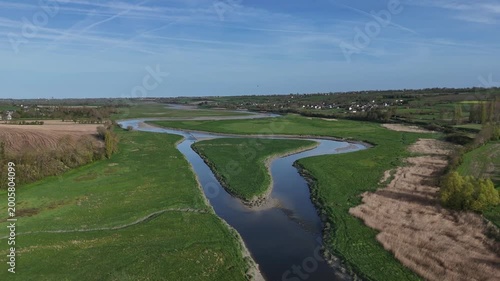 Survol de la Sienne, rivière entre Regnéville-sur-Mer et Heugueville-sur-Sienne, peu avant sa rencontre avec la Manche. Traveling arrière jusqu'au pont de la Roque.