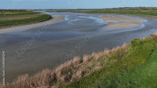 Survol de la Sienne, rivière entre Regnéville-sur-Mer et Heugueville-sur-Sienne, peu avant sa rencontre avec la Manche. Traveling vertical ascendant.