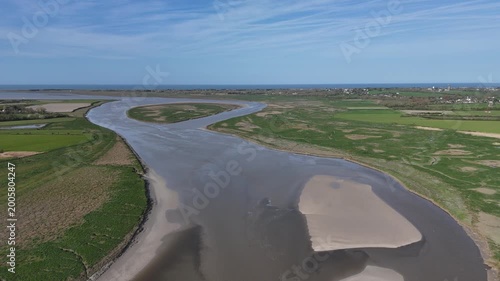 Survol de la Sienne, rivière entre Regnéville-sur-Mer et Heugueville-sur-Sienne, peu avant sa rencontre avec la Manche. Traveling vertical descendant.