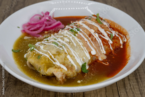 Hearty wet burrito smothered in red and green sauce split in half to satisfy that urge for a Mexican food meal