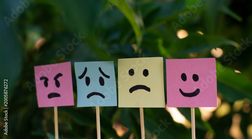 Tableau sur toile Different emotional faces on colorful sticky notes with blurred background