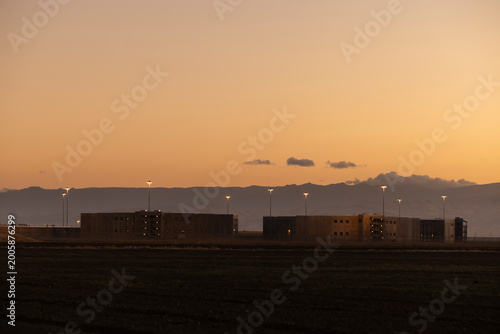 Tablou pe pânză Sunset view of a federal prison on the outskirts of the city of Mendota, California, USA