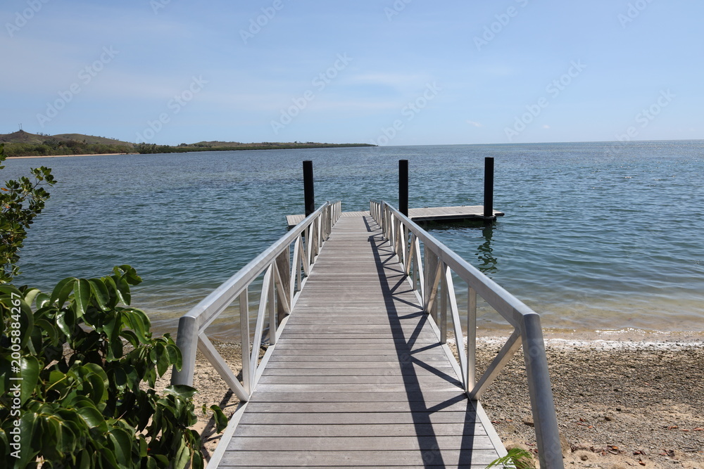 Obraz premium long narrow wooden walkway to small dock in strong tropical sunshine (close-up) 3509