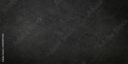 A dark textured black leather surface with a macro closeup pattern of old rough material creates a grunge textile background for a design wallpaper or backdrop