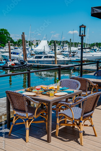 Foto Outdoor dining table with seafood and cocktails at marina