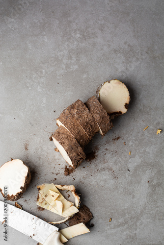 Overhead view of slices of yam on a grey countertop, Top view of african yam slices on grey background, cut pieces of Old Nigerian yam tuber for cooking