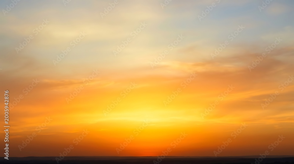Obraz premium Vibrant sunset sky with layered orange, yellow, and blue clouds