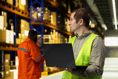 Cuadro en lienzo Male worker organizing packages in fulfillment center storage room