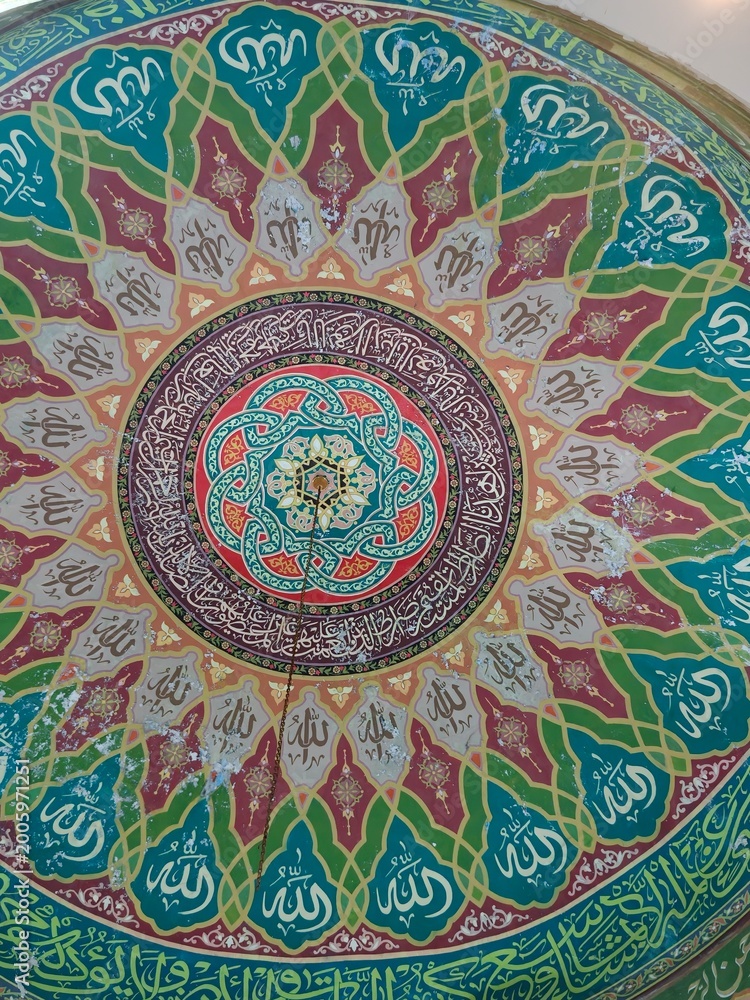 Fototapeta premium Intricate Islamic Calligraphy and Geometric Patterns Adorning a Mosque Dome Interior.